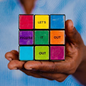 hand holding rubik cube that says "let's figure it out"